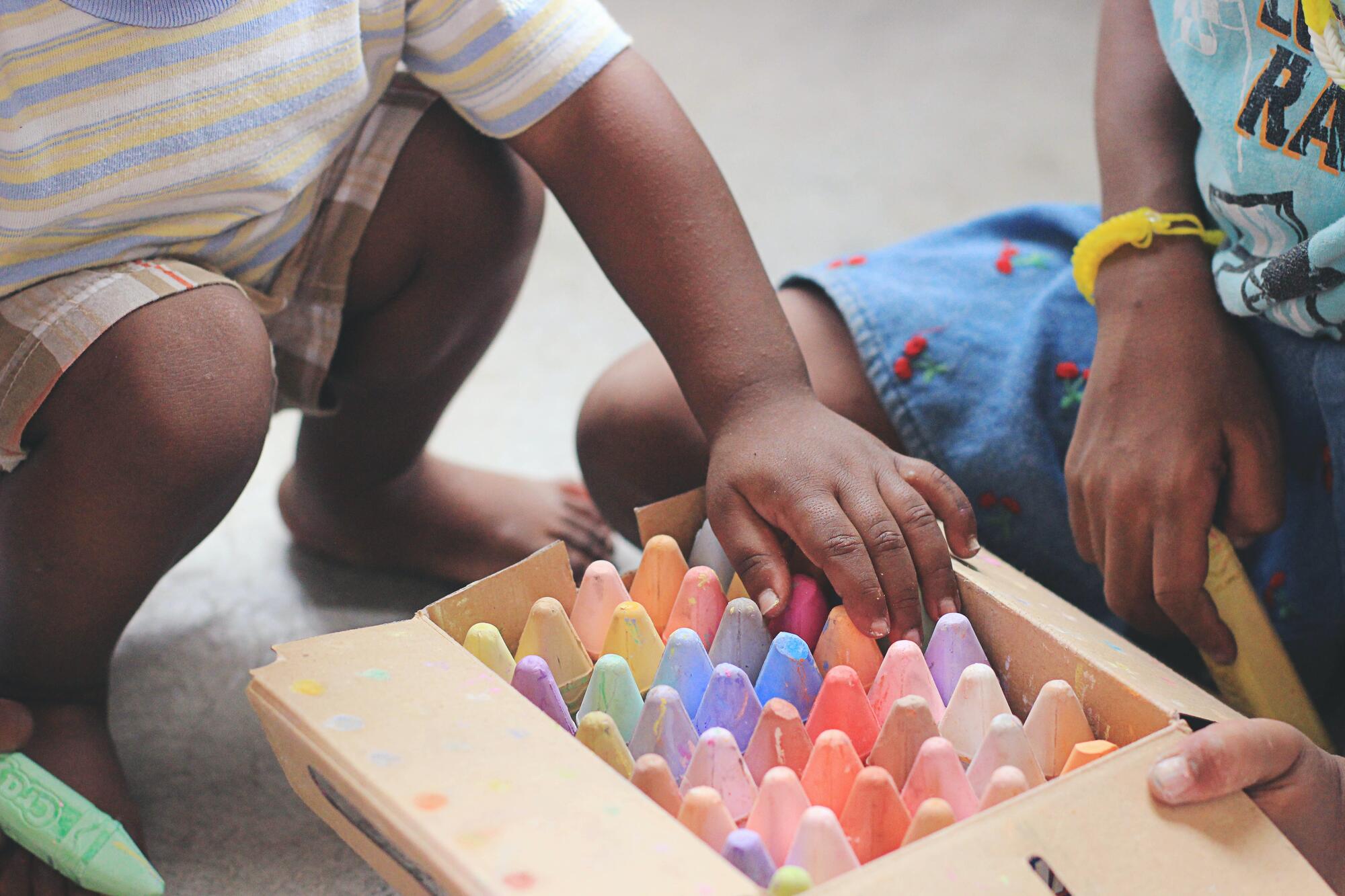 little boy with a box of colored chalk