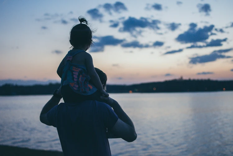  Daughter sitting on father's shoulders