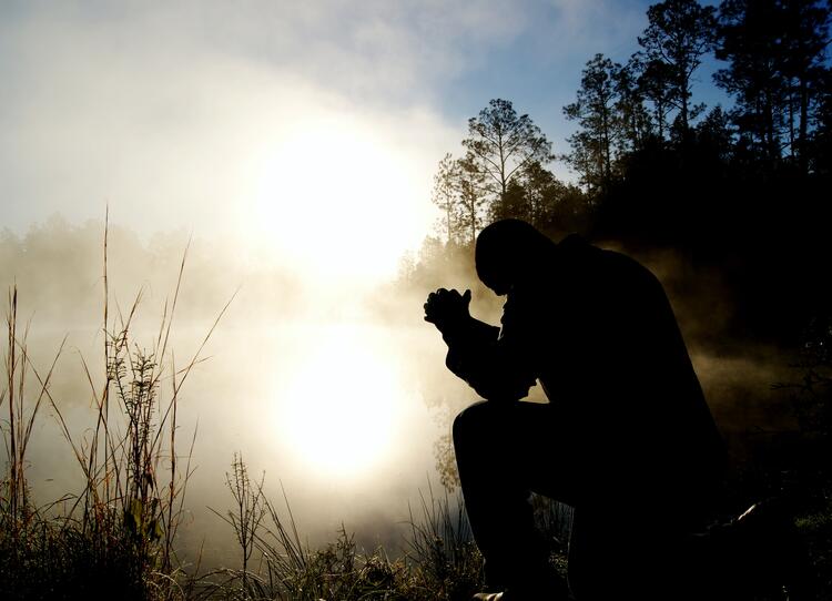 Someone praying in the shadows